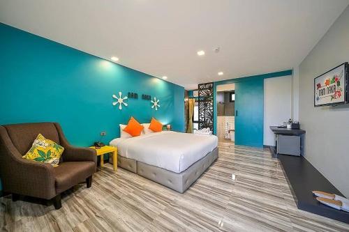 um quarto de hotel com uma cama, uma cadeira e um sofá em Nam Naka Boutique Hotel - SHA Plus em Phuket