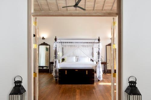 a bedroom with a bed and a ceiling fan at Haritha Villas & Spa in Hikkaduwa