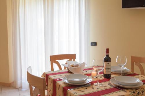 a dining room table with a bottle of wine and glasses at Residence Hotel Raggio Di Luce in Ponte di Legno
