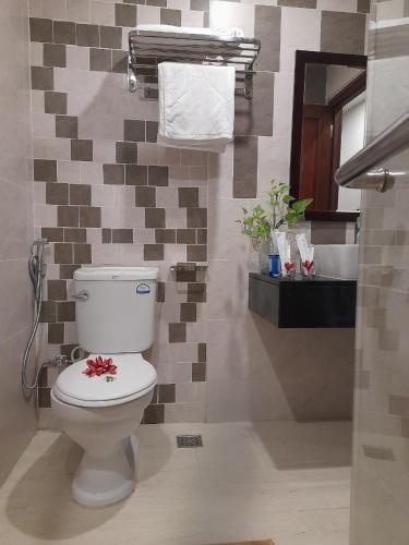 a bathroom with a toilet with a flower on it at Happy Home in Nha Trang