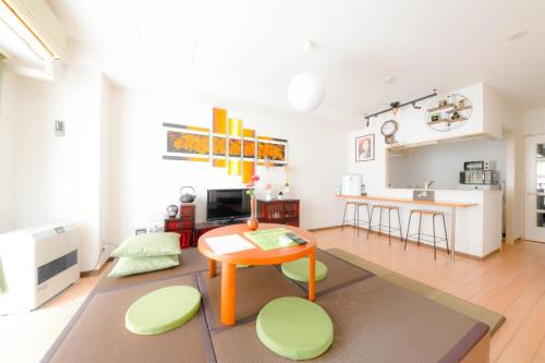 a living room with a table and a kitchen at 37MB HOTEL in Sapporo