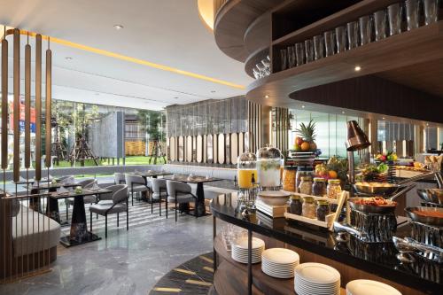 a restaurant with tables and chairs and a bar at Oakwood Suites Tiwanon Bangkok in Nonthaburi