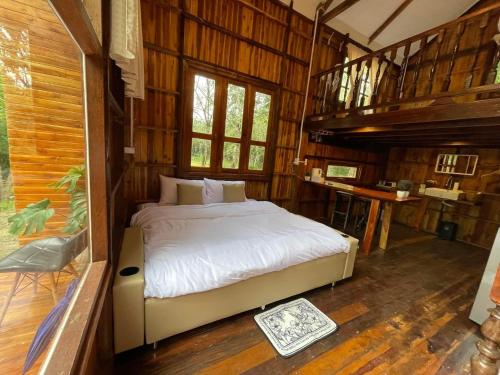 Ban Don KlangにあるBaanraipoonwana Baanboonmakの木製の部屋にベッド1台が備わるベッドルーム1室があります。