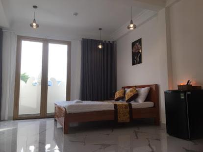 a bedroom with a bed and a large window at Khách sạn KEN HOTEL DĨ AN in Dĩ An