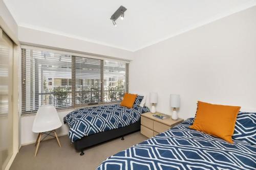 two beds in a bedroom with a window at The Summit E2 Kingston ACT in Kingston 
