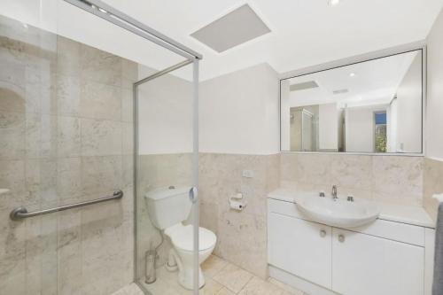 uma casa de banho com um WC, um lavatório e um chuveiro em The Summit E2 Kingston ACT em Kingston 