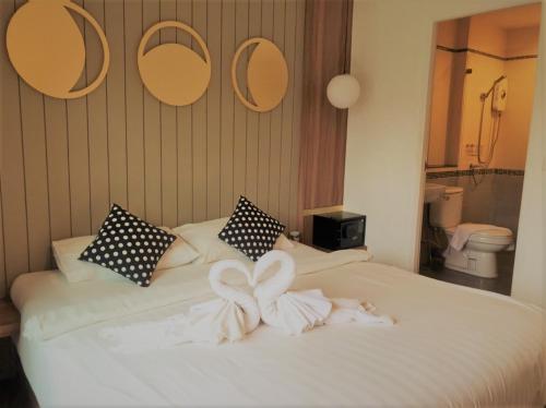a bedroom with a bed with two towels on it at La La Moon Krabi Poshtel'n' Pool in Krabi town