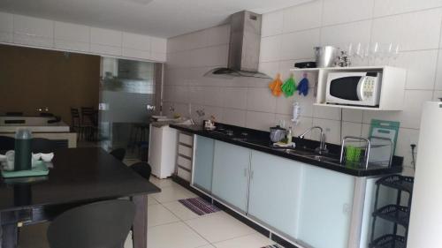 a kitchen with a sink and a microwave at Casa com 2 quartos e banheira de Hidromassagem in Trindade