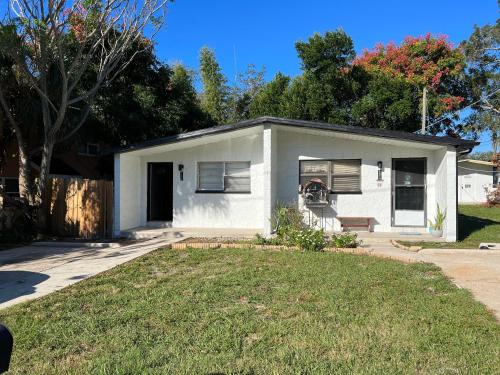 a small white house with a lawn in front of it at Bohemian 1 Bedroom- Minutes from Busch Gardens in Tampa