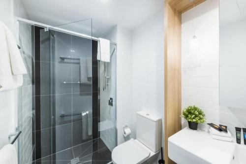 a bathroom with a toilet and a glass shower at Accommodate Canberra - Highgate in Canberra