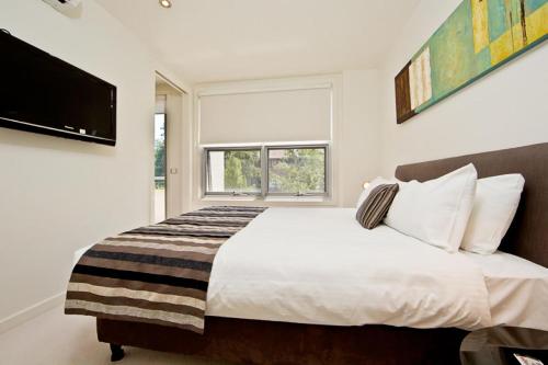 a bedroom with a large bed and a television at Accommodate Canberra - Trieste in Canberra