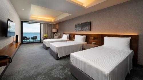 a hotel room with two beds and a view of the ocean at The Reef Island Resort Mactan, Cebu in Mactan