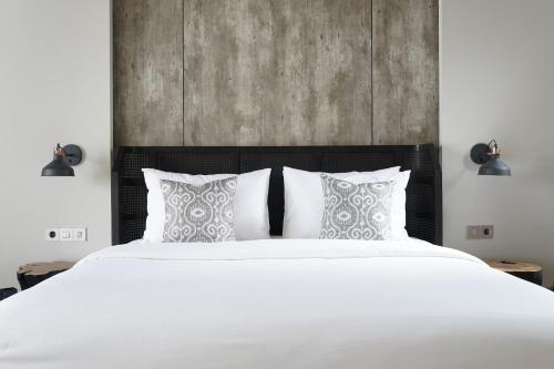 a bedroom with a large white bed with pillows at Umah Tirta in Ubud