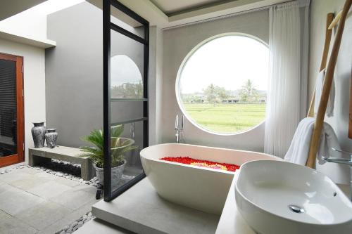 a bathroom with a large bath tub and a window at Umah Tirta in Ubud