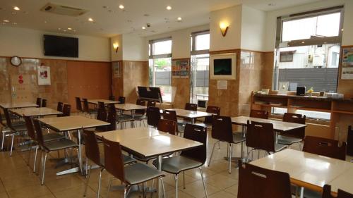 an empty dining room with tables and chairs at Toyoko Inn Shin-shirakawa Ekimae in Nishigo