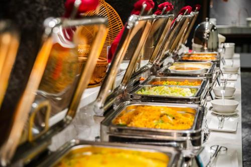 Mường Thanh Holiday Suối Mơ Hạ Long في ها لونغ: طابور بوفيه مع العديد من صواني الطعام