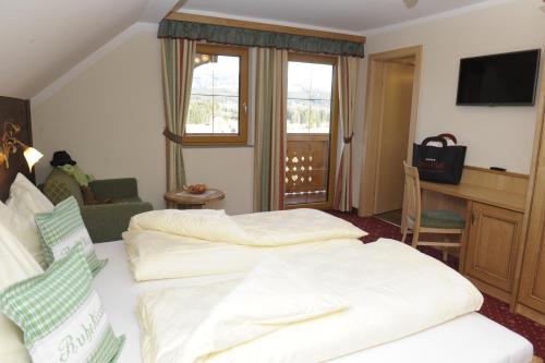a hotel room with two beds and a desk at Bio-Bauernhof Samerhof in Mariapfarr