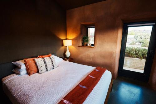 ein Schlafzimmer mit einem Bett mit Kissen und einem Fenster in der Unterkunft Sacred Sands in Joshua Tree