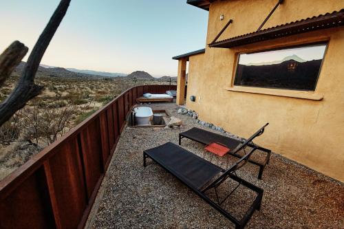 a chair and a table on a balcony of a house at Sacred Sands in Joshua Tree