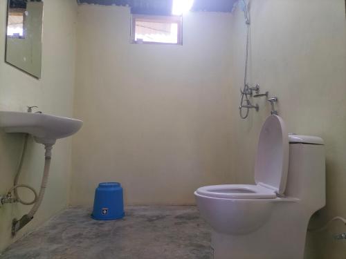 a bathroom with a white toilet and a sink at Namaste Bardiya Resort in Bhurkīā