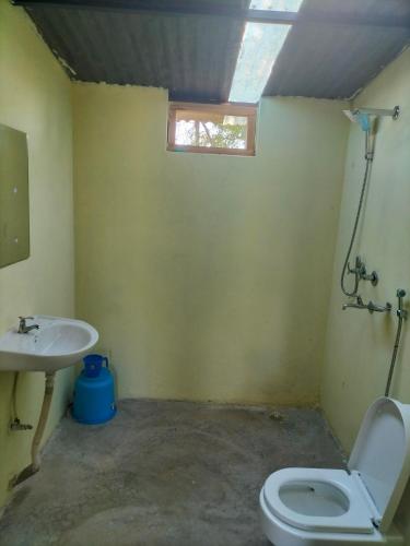 a bathroom with a toilet and a sink at Namaste Bardiya Resort in Bhurkīā