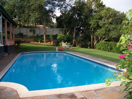 a large blue swimming pool in a yard at Birdcage B&B in Amanzimtoti