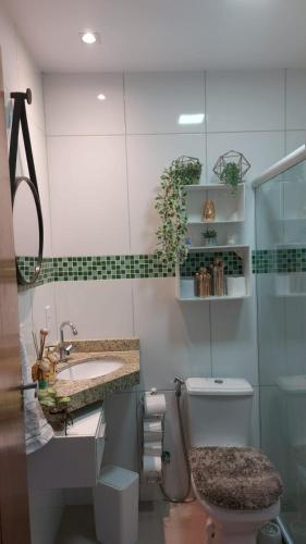 a bathroom with a toilet and a sink at Casa Duplex Condomínio Ipanema no Peró in Cabo Frio