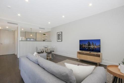 a living room with a couch and a flat screen tv at The Prince 228 Kingston ACT in Canberra