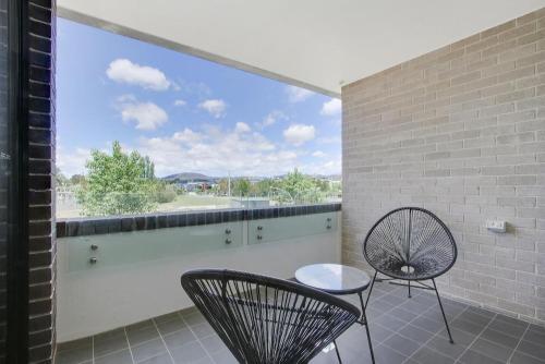 a balcony with two chairs and a large window at The Prince 228 Kingston ACT in Canberra