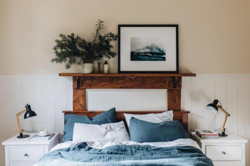 a bedroom with a bed with a wooden head board at Naivasha Cottage in Deloraine