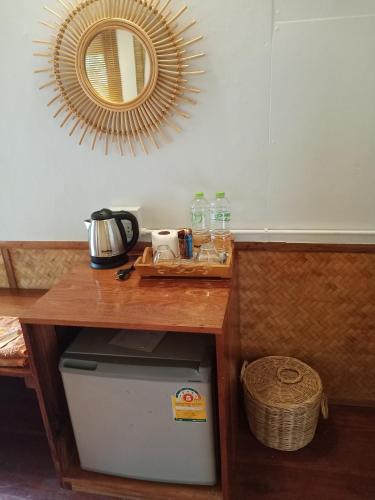 a wooden table with a mirror and a trash can at Mookies Bungalows in Koh Mook