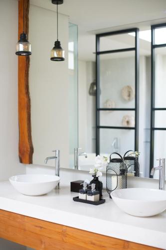 a bathroom with two sinks and a mirror at Umah Tirta in Ubud