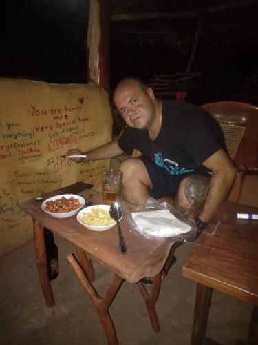 a man sitting on a chair next to a table at Relax Nature Villa in Sigiriya