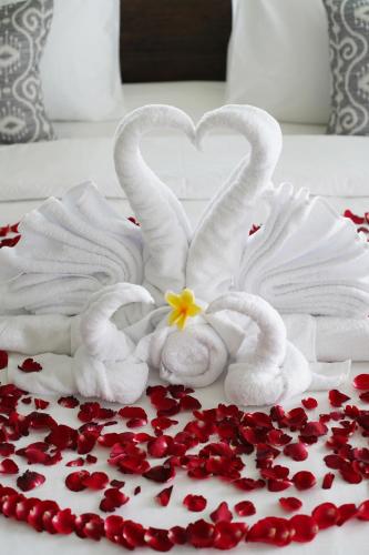 two white swans making a heart with a flower on a cake at Umah Tirta in Ubud