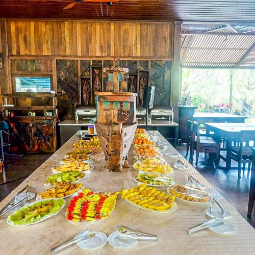 a table with many plates of fruit on it at Long Hải Channel Beach Resort in Long Hai