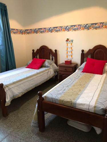 a bedroom with two beds with red pillows on them at Urqu-Pacha Alojamiento in Tinogasta