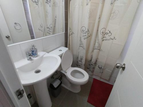 uma casa de banho com um WC branco e um lavatório. em Casa con estacionamiento en sector residencial em Puerto Montt