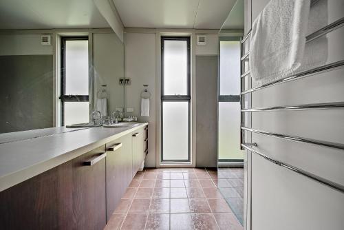 a kitchen with a refrigerator and some windows at Ecocrackenback 2 Sustainable chalet close to the slopes in Crackenback