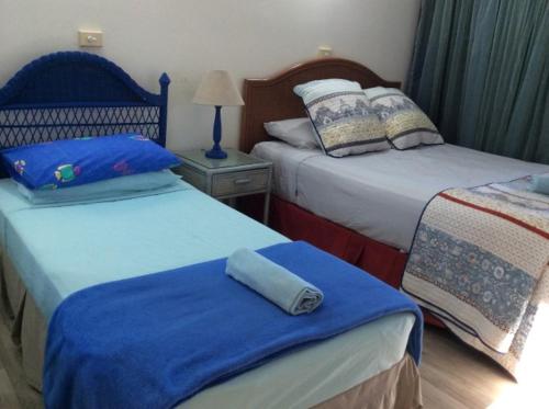 um quarto com 2 camas com lençóis azuis e brancos em Ulysses 10 em Mission Beach