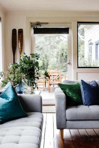 a living room with two couches and a window at Naivasha Cottage in Deloraine