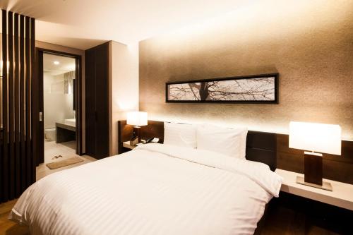 a bedroom with a white bed and two lamps at Sono Felice Village Vivaldi Park in Hongcheon