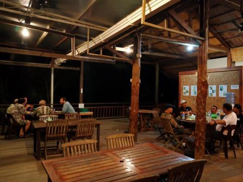 a group of people sitting at tables in a restaurant at Sepilok B&B in Sepilok