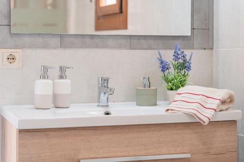 a bathroom sink with two towels and flowers on it at Finca Ses Pomeres in Puigpunyent