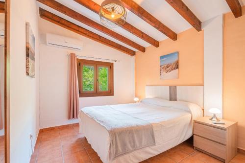 a bedroom with a bed and a window at Finca Ses Pomeres in Puigpunyent