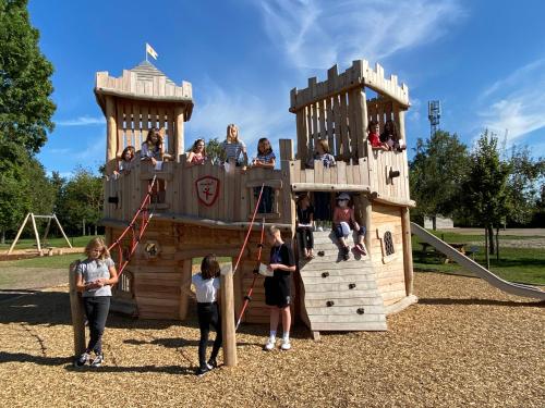 a group of children playing on a wooden playground at Gite Westhouse in Westhouse