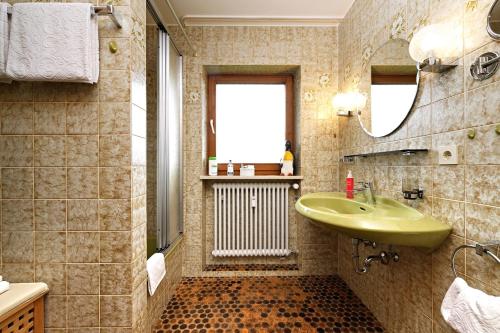 La salle de bains est pourvue d'un lavabo vert et d'un miroir. dans l'établissement Ferienwohnung Karin, à Kierwang