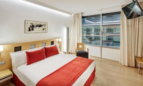 a hotel room with a bed and a large window at Sercotel Caspe in Barcelona