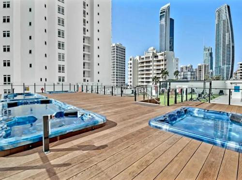 a rooftop deck with two hot tubs on a building at Ocean View Studio Surfers Paradise in Gold Coast