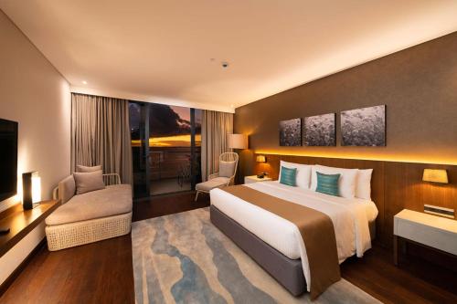 um quarto de hotel com uma cama grande e uma televisão em The Reef Island Resort Mactan, Cebu em Mactan
