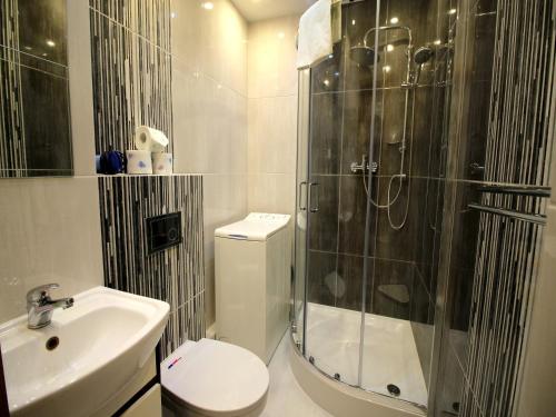 a bathroom with a shower and a toilet and a sink at Happy Apartments - Economy in Wrocław